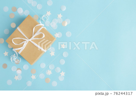 Paper gift box tied with ribbon, star and circle paper confetti or glitters Paper gift box tied with ribbon, star and circle paper confetti or glitters 76244317