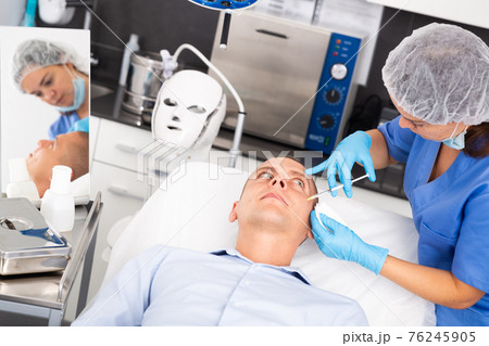 Man receiving cosmetic facial injection in clinic Man receiving cosmetic facial injection in clinic 76245905
