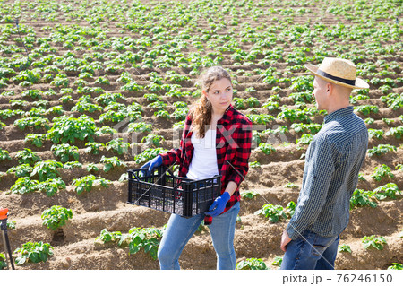 Two farmers talking among themselves during a break in work on field Two farmers talking among themselves during a break in work on field 76246150