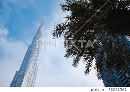 DUBAI, UNITED ARAB EMIRATES - FEBRUARY 10, 2021: Bottom-up view of Burj Khalifa in contrast with the blue sky and clouds. DUBAI, UNITED ARAB EMIRATES - FEBRUARY 10, 2021: Bottom-up view of Burj Khalifa in contrast with the blue sky and clouds. 76248561