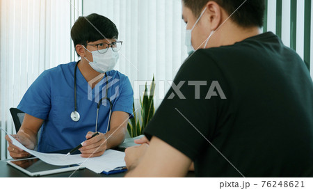 Doctors are explaining the treatment of a patient's illness while wearing a mask during the epidemic. Doctors are explaining the treatment of a patient's illness while wearing a mask during the epidemic. 76248621
