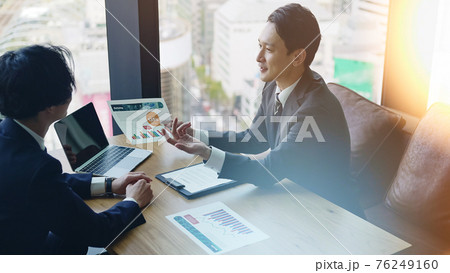 オフィスで会話するビジネスマン 76249160
