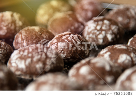 Cracked chocolate cookies with icing sugar on a pan Cracked chocolate cookies with icing sugar on a pan 76251688