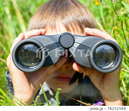 Child looking through binoculars Child looking through binoculars 76252569