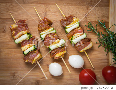 Raw lamb skewers with zucchini slices on wood Raw lamb skewers with zucchini slices on wood 76252718
