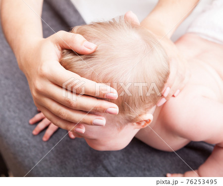 Little baby receiving osteopathic treatment of her skull and neck Little baby receiving osteopathic treatment of her skull and neck 76253495