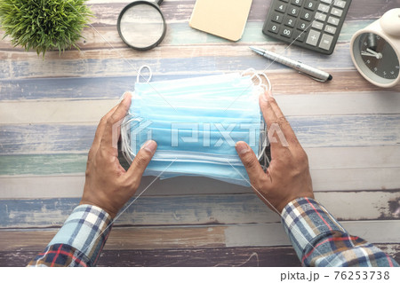 Close up of blue surgical masks on office deks Close up of blue surgical masks on office deks 76253738