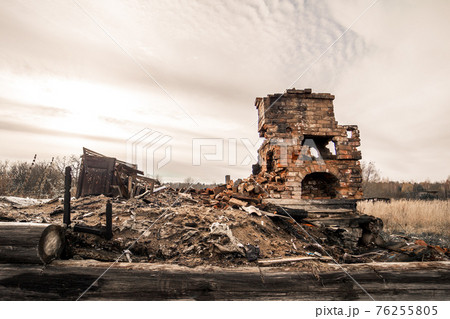 A destroyed heating stove standing alone in a vacant lot. A destroyed heating stove standing alone in a vacant lot. 76255805
