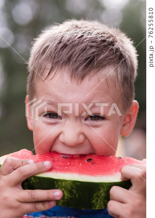 The boy eats watermelon with delight. The boy eats watermelon with delight. 76255810