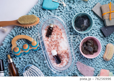 natural  healing  spa set with salt, healing mud and soap on blue bath mat. flay lay 76256996