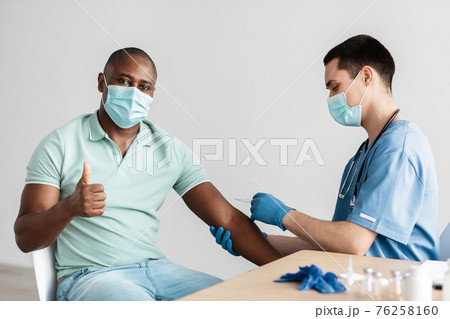 Positive man gets vaccine, thumb up, doing excellent and approval sign gesture 76258160