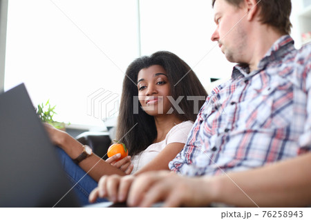 Man and a woman are sitting on the couch with laptop. Man and a woman are sitting on the couch with laptop. 76258943