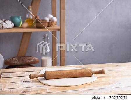 Wheat dough at flour powder and rolling pin on table for homemade bread cooking or baking Wheat dough at flour powder and rolling pin on table for homemade bread cooking or baking 76259251