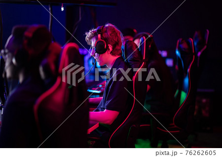 Training bootcamp for professional esports players. Young cyber-athletes play an online shooter game. Glowing keyboard, neon light. Training bootcamp for professional esports players. Young cyber-athletes play an online shooter game. Glowing keyboard, neon light. 76262605