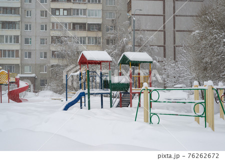 childrens play complex and bench in snow around the building 76262672