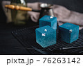 Blue cake filled with orange and tangerine in the shape of a cube. Rustic style. 76263142