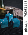 Blue cake filled with orange and tangerine in the shape of a cube. Rustic style. 76263143