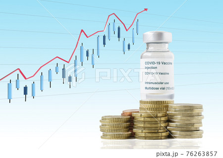 Coronavirus vaccine vial on top of a pile of coins on a candlestick graphic in the background of the screen monitor. Coronavirus vaccine vial on top of a pile of coins on a candlestick graphic in the background of the screen monitor. 76263857