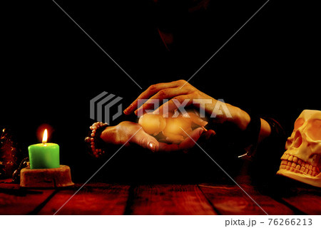 A fortune-teller or oracle with objects for fortune-telling holds a baby doll in her hands during the session. Psychic readings and the concept of clairvoyance A fortune-teller or oracle with objects for fortune-telling holds a baby doll in her hands during the session. Psychic readings and the concept of clairvoyance 76266213