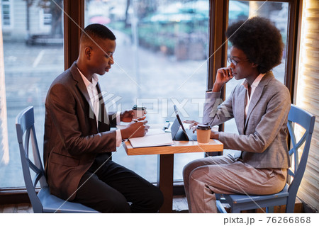 Two african people in formal clothes sitting at cafe 76266868