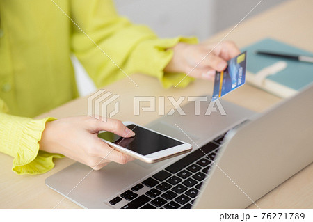 Closeup young asian business woman using smart phone and holding credit card while online shopping. Closeup young asian business woman using smart phone and holding credit card while online shopping. 76271789