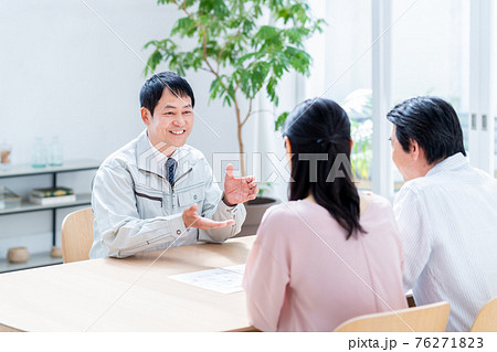 シニアの夫婦にリフォームの営業をするビジネスマン　 76271823