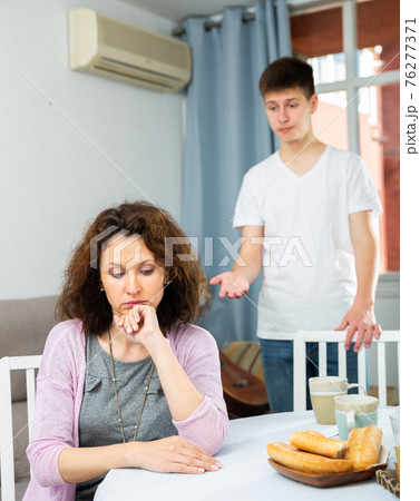 Upset woman after quarrel with teenage son Upset woman after quarrel with teenage son 76277371