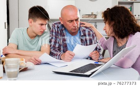 Chagrined family analyzing finances 76277373