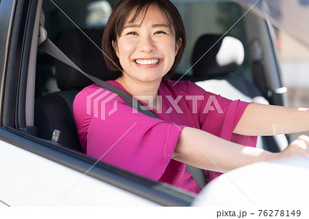 車を運転する若い女性 76278149
