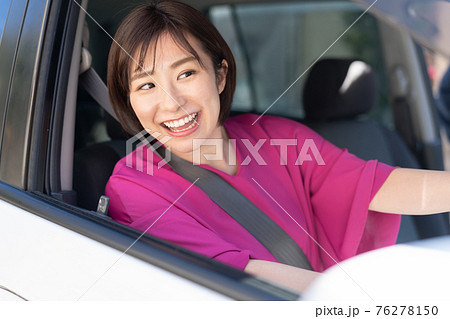 車を運転する若い女性 76278150