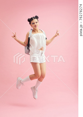 Full length profile photo of funny student lady jumping high showing v-sign symbols wear bag isolated pink color background Full length profile photo of funny student lady jumping high showing v-sign symbols wear bag isolated pink color background 76278274