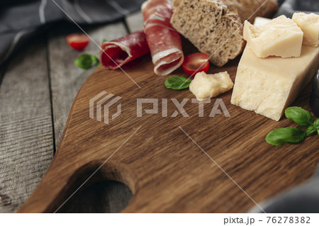 Italian cuisine concept. Parmesan Cheese chunks, ham, tomato, basil, bread toast 76278382