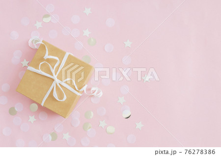 Paper gift box tied with ribbon, star and circle paper confetti or glitters 76278386
