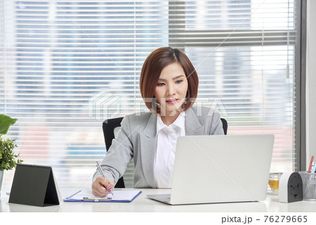 Young, attractive and confident business woman working in office Young, attractive and confident business woman working in office 76279665
