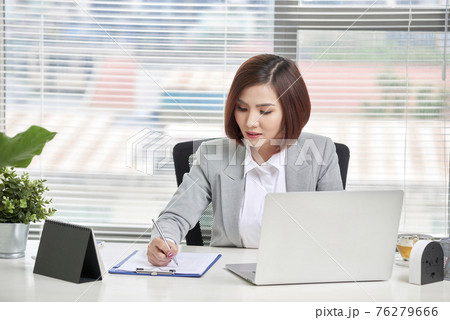 Young, attractive and confident business woman working in office 76279666