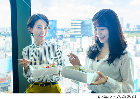 オフィスでテイクアウトのお弁当を食べるビジネスウーマン 76280031