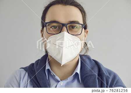 Headshot of man wearing KN95 face mask to protect himself from Covid 19 infection 76281256
