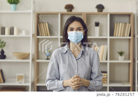 Caucasian woman in protective face mask looking at camera home office portrait Caucasian woman in protective face mask looking at camera home office portrait 76281257