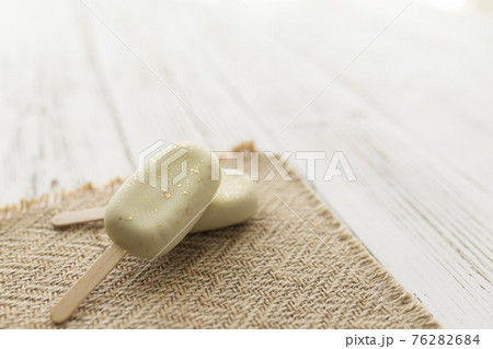 White shiny cookie ice creams on a stick on wooden background White shiny cookie ice creams on a stick on wooden background 76282684