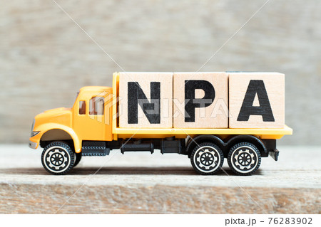 Toy truck hold alphabet letter block in word NPA (Abbreviation of Non performing assets or Nasopharyngeal airway) on wood background 76283902