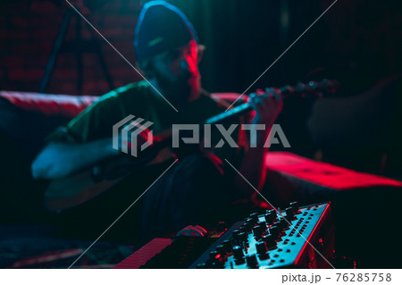 Close-up of musician performing in neon light. Concept of advertising, hobby, music, festival, entertainment. 76285758