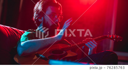 Close-up of musician performing in neon light. Concept of advertising, hobby, music, festival, entertainment. Close-up of musician performing in neon light. Concept of advertising, hobby, music, festival, entertainment. 76285763
