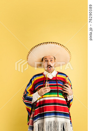 Portrait of surprised man in bright garment isolated over yellow background Portrait of surprised man in bright garment isolated over yellow background 76290389