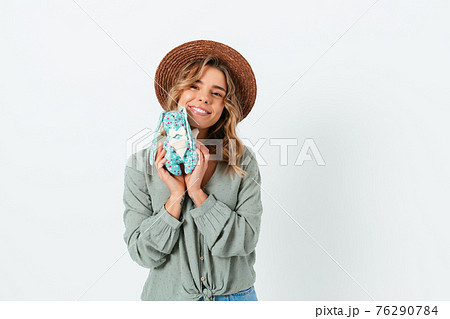 Cute happy blonde young woman wearing straw hat and casual green blouse Cute happy blonde young woman wearing straw hat and casual green blouse 76290784