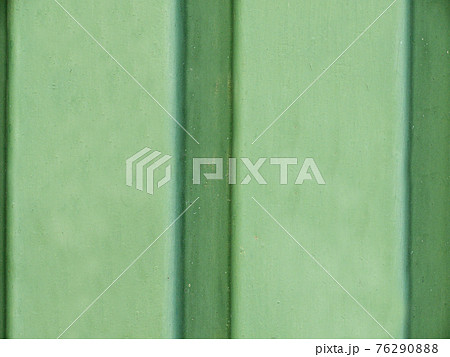 Close-up of the smooth surface of the green wall with striped vertical stripes 76290888