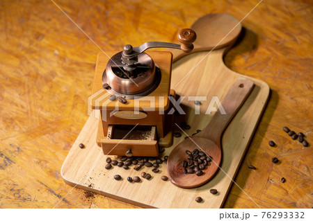 ..Manual coffee grinder placed on a wooden floor. 76293332