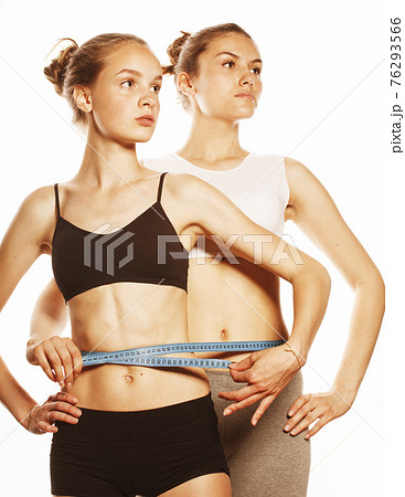 two sport girls measuring themselves isolated on white 76293566