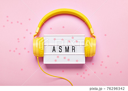 Yellow headphones, ASMR letters lightbox and confetti on pink background. ASMR Stress-relieving sounds concept, flat lay Yellow headphones, ASMR letters lightbox and confetti on pink background. ASMR Stress-relieving sounds concept, flat lay 76296342
