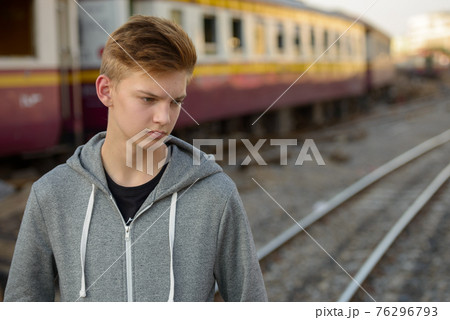 Young handsome teenage boy at the railway train station Young handsome teenage boy at the railway train station 76296793
