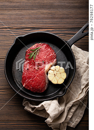 Raw beef steak on frying pan from above 76298177